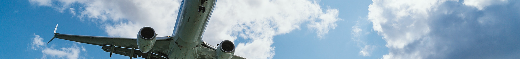 Airplane flying through the clouds during the day, blue sky and sunlight