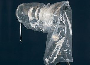 Camera covered with a plastic rain cover on a tripod theshutterbug.